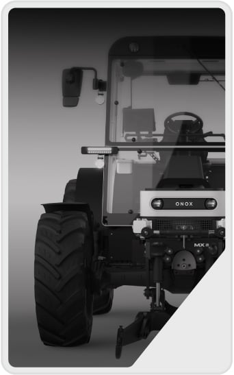 A grayscale image shows the front view of a modern tractor with large treaded tires, visible side mirrors, and a steering wheel inside the cab. The tractor has the word "ONOX" displayed on the front.