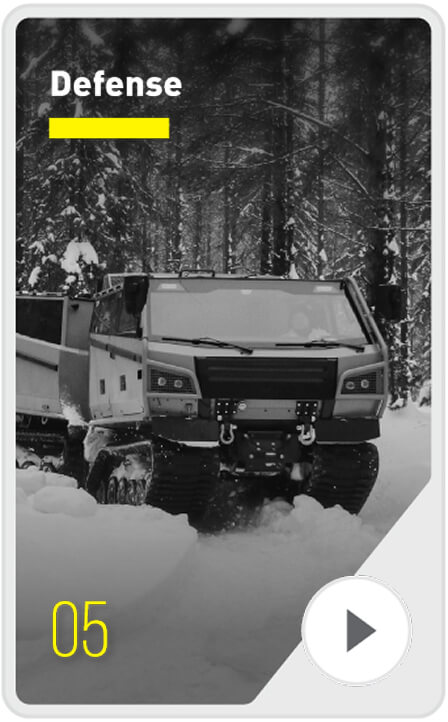 A tracked military vehicle drives through a snowy forest. The word "Defense" appears at the top left, and the number 05 is shown at the bottom left. A play button icon is at the bottom right.