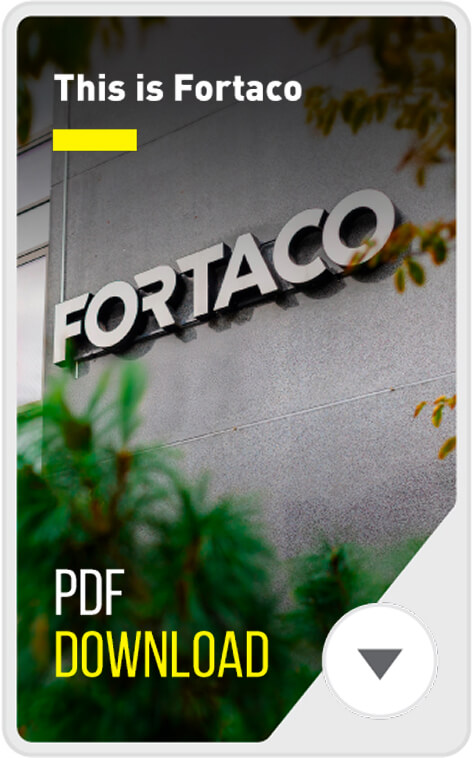 A building with the word "FORTACO" on its exterior wall, partially obscured by green foliage. Text reads, "This is Fortaco" and "PDF DOWNLOAD" with a downward arrow icon.